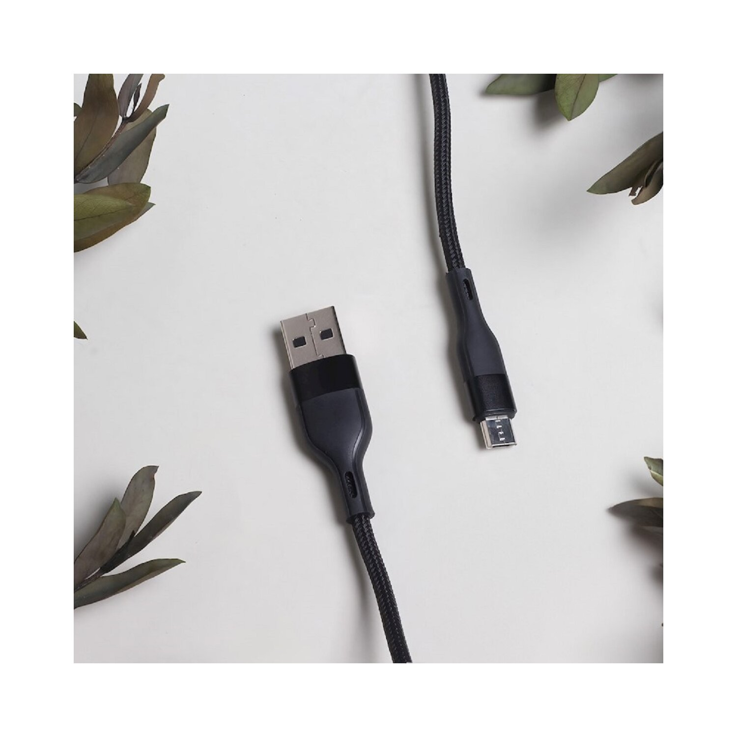 USB-Kabel mit USB-A- und Micro-USB-Anschluss, schwarz und auf weißer Oberfläche liegend.