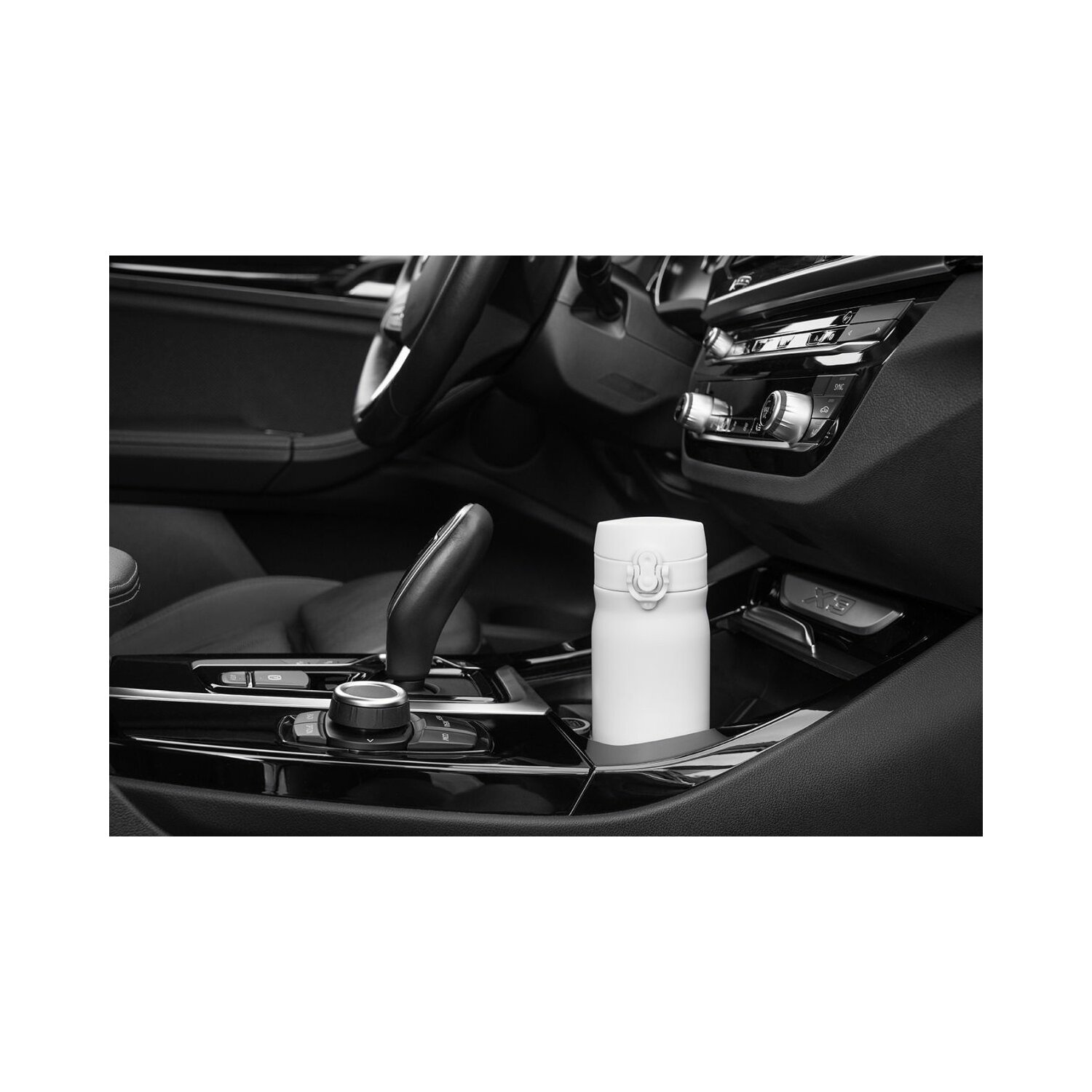Weißer, vakuumversiegelter Becher in der Mittelkonsole eines Autos.