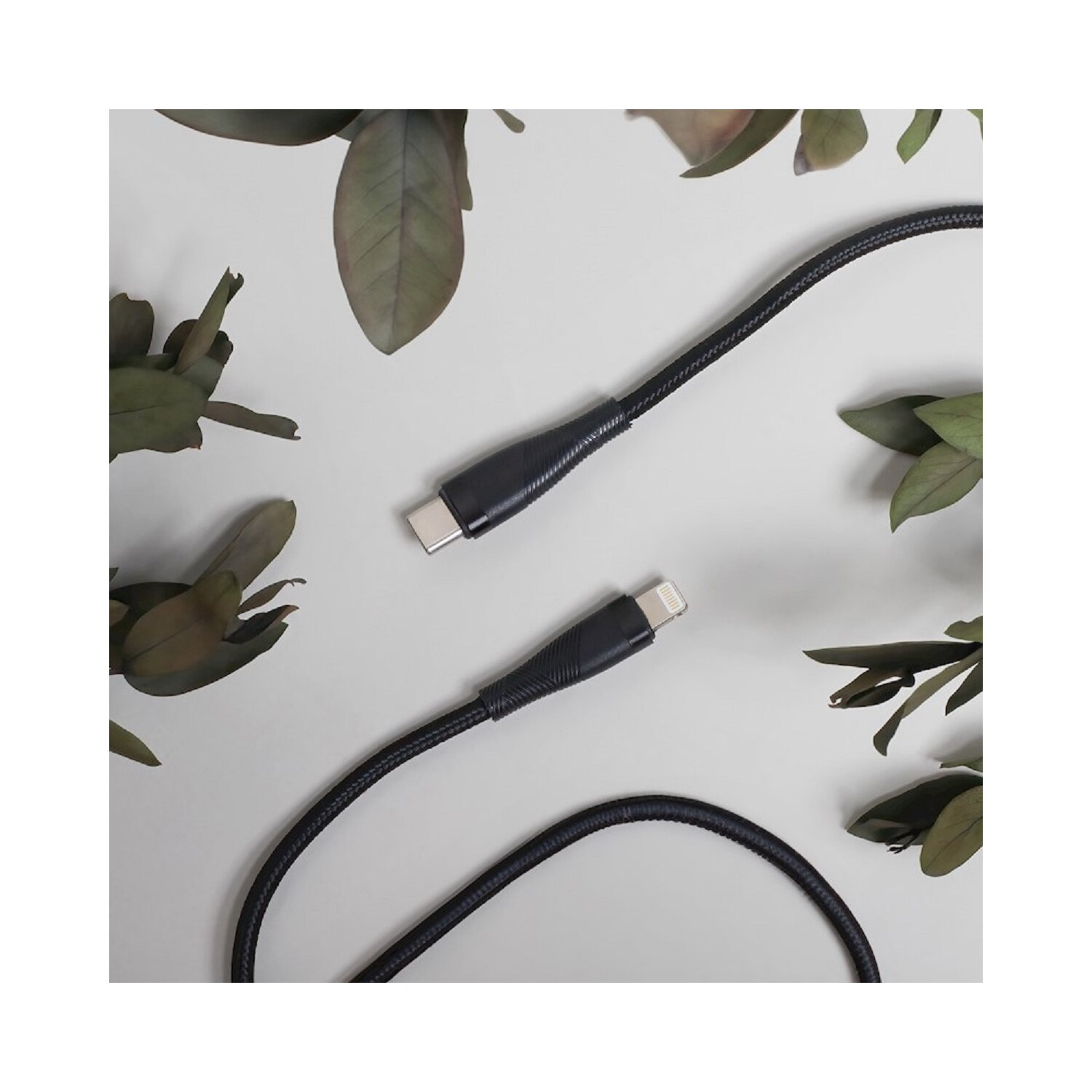 Nahaufnahme von schwarzen Ladekabeln mit USB-C- und Lightning-Anschlüssen auf hellem Hintergrund.