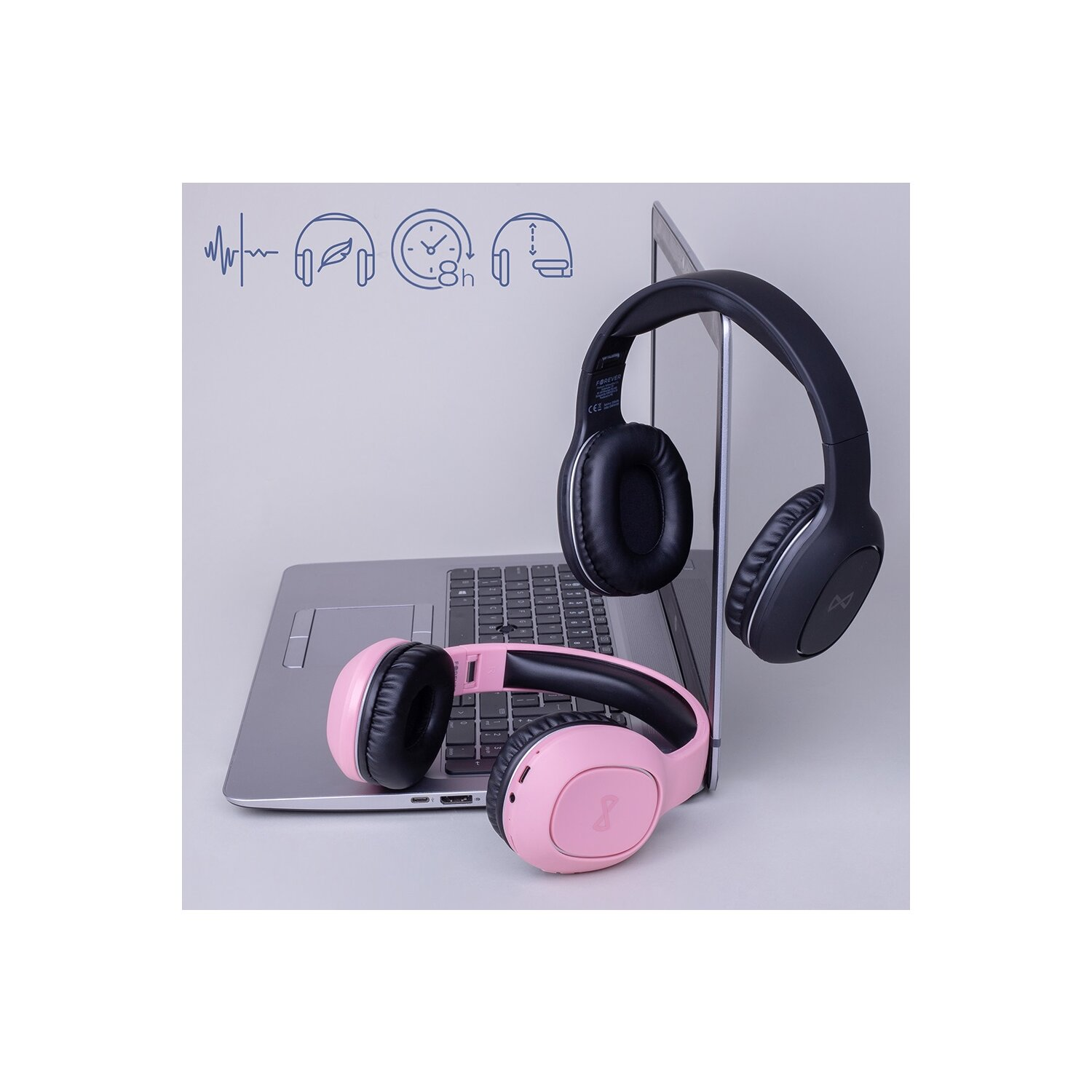 Zwei Kopfhörer, einer pink und einer schwarz, neben einem Laptop. Symbole oben.