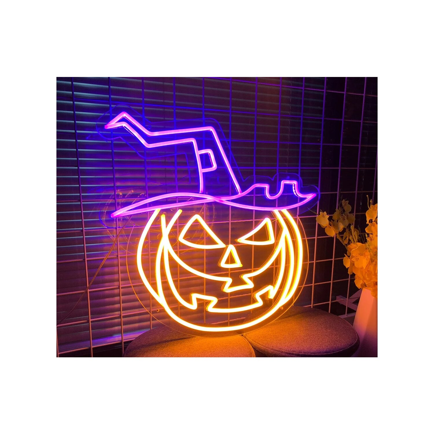 Neon-Kürbiskopf mit Hut, orange leuchtend mit rosa Hut, auf Gitterhintergrund.