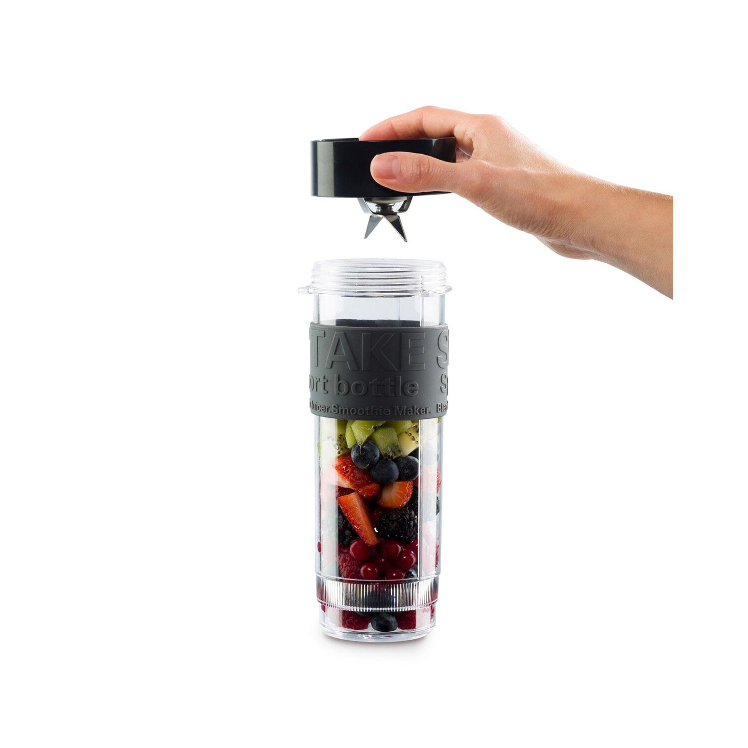 İçinde meyve olan şeffaf bir smoothie makinesi. Bir el üst kısmı yerleştiriyor.