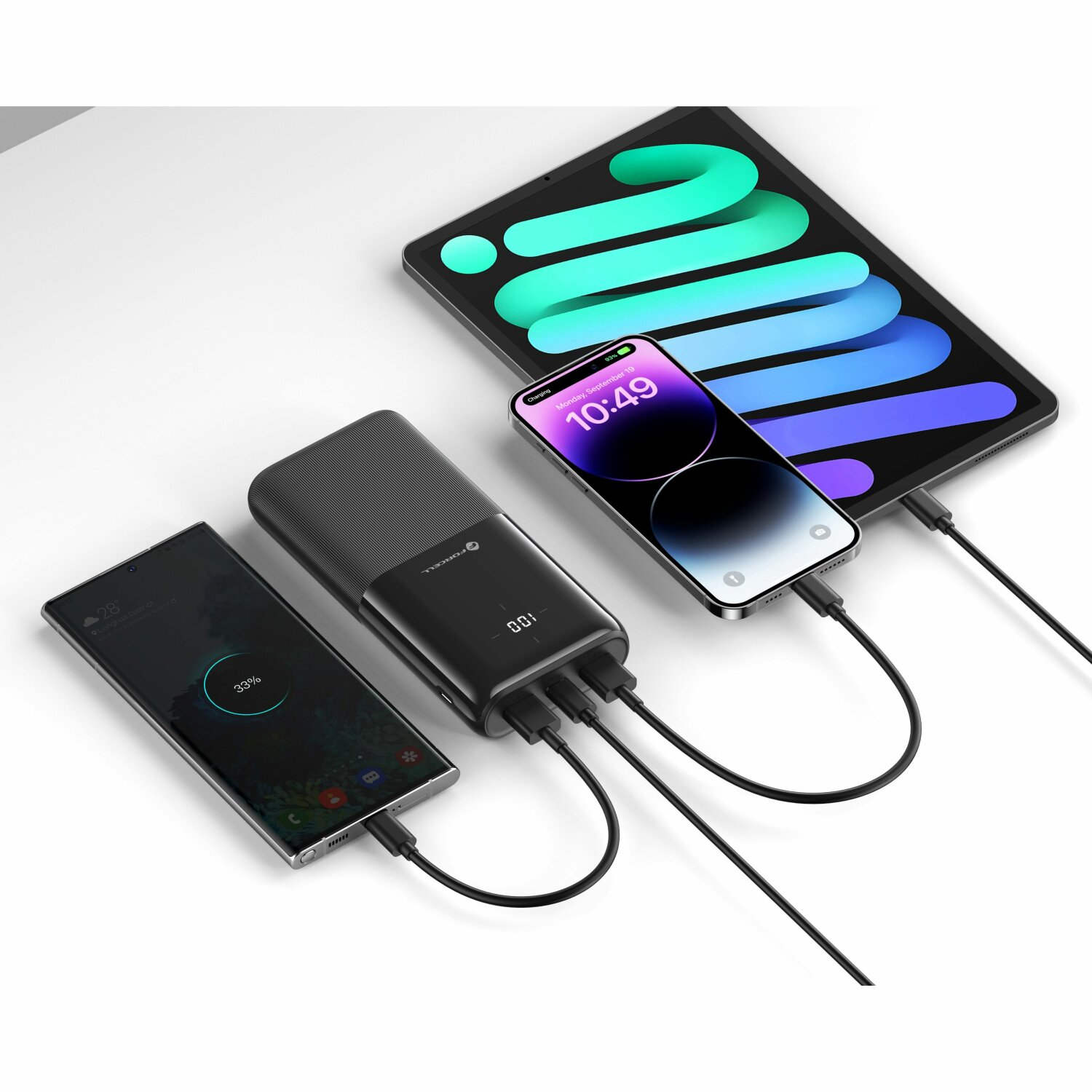 Ein Tablet und zwei Telefone sind an eine Ladestation angeschlossen. Alle Geräte zeigen unterschiedliche Ladezustände.