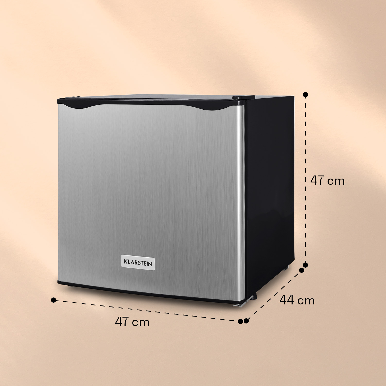 Mini-nevera plateada con lados negros, logotipo de la marca y dimensiones sobre fondo beige.