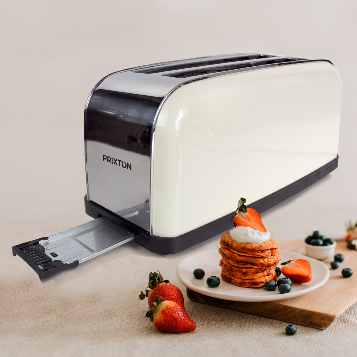 Kremowy toster z chromowanymi akcentami, stos naleśników i truskawki.