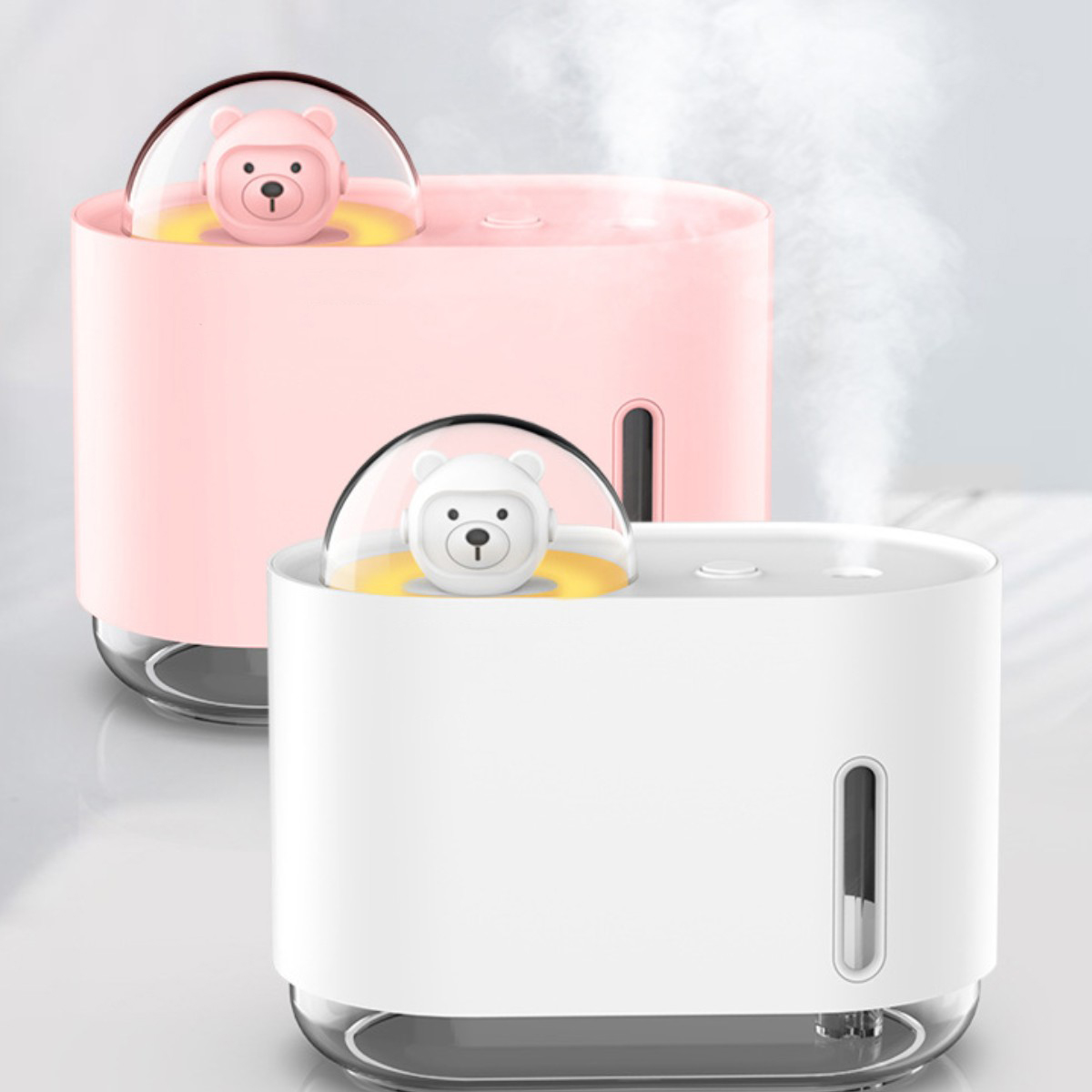Zwei Luftbefeuchter: einer rosa, einer weiß, jeweils mit einer Bärenfigur in einer Kuppel.