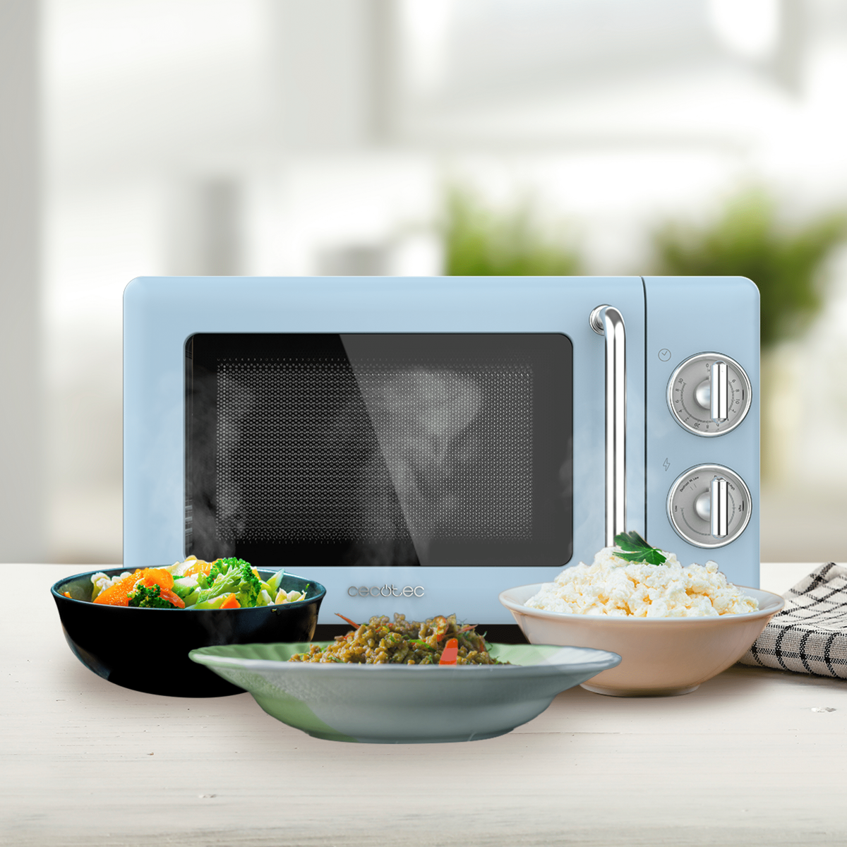 Niebieska kuchenka mikrofalowa z jedzeniem w miskach. Warzywa, ryż i inne dania są widoczne na stole.