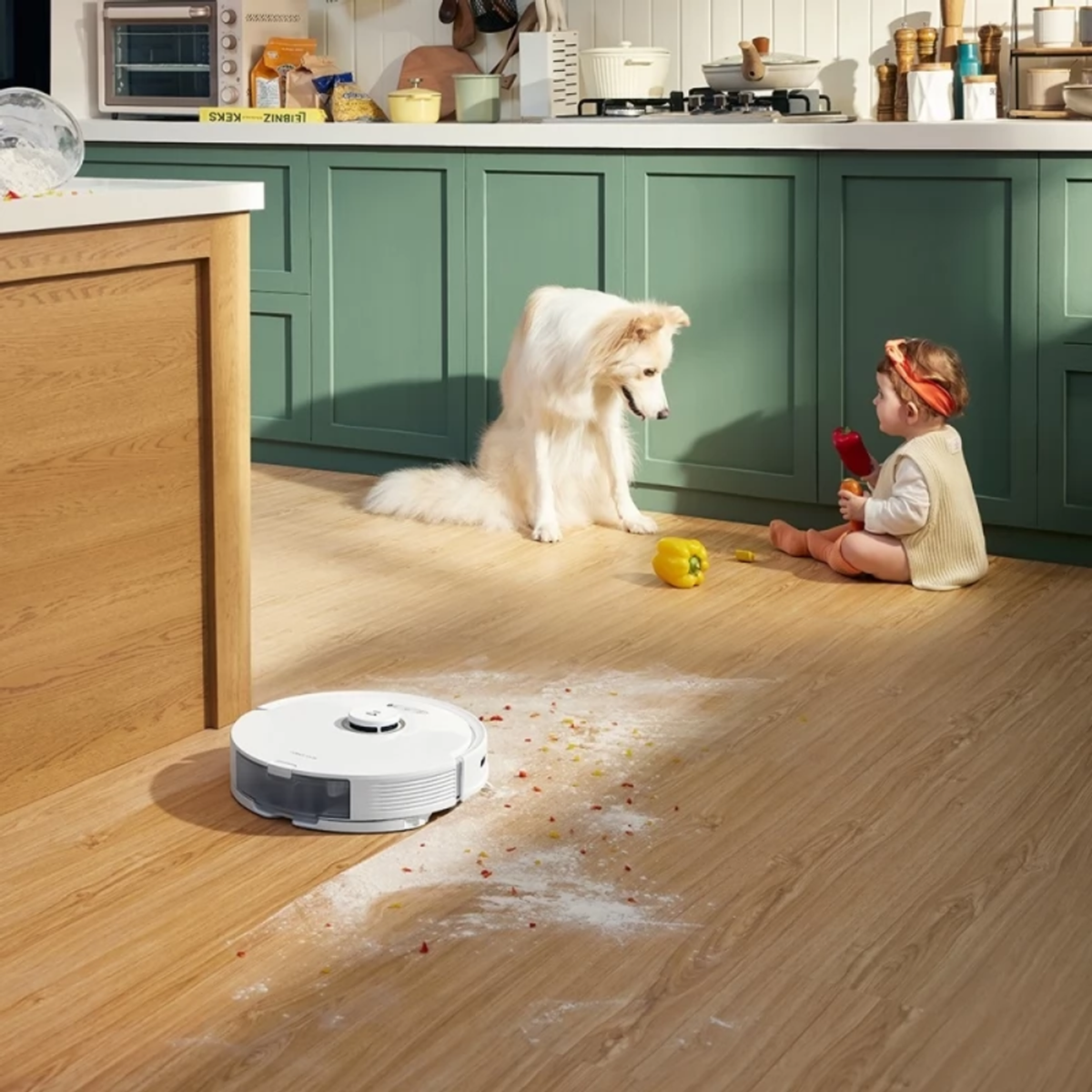 Dziecko i pies w kuchni. Na podłodze odkurzacz robot.