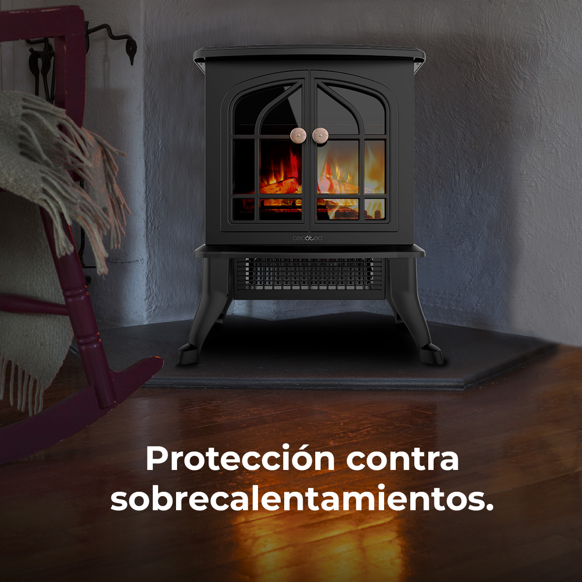 Caminetto elettrico nero con effetto fuoco. Una sedia a dondolo e una coperta sono sullo sfondo.