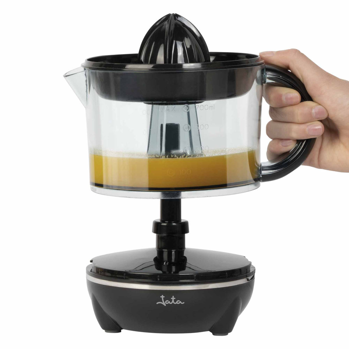 Un exprimidor negro y transparente con una mano sosteniendo el mango. El exprimidor contiene jugo de naranja.