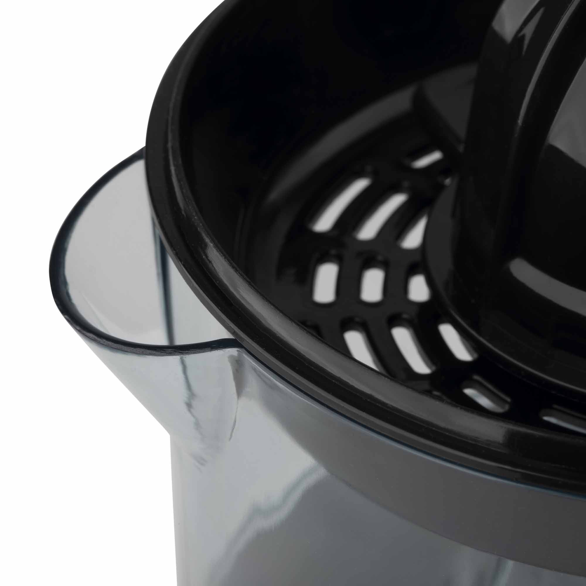 Primer plano de una exprimidora con recipiente transparente y partes negras, sobre fondo blanco.