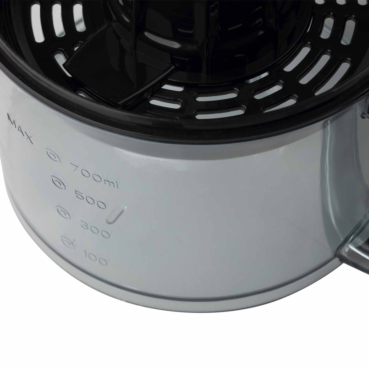 Primer plano de un recipiente de exprimidor de plástico transparente con marcas de volumen y un interior negro.