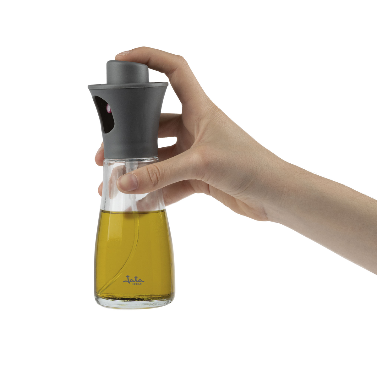 Una mano sosteniendo un pulverizador de aceite de vidrio, lleno de aceite de oliva.