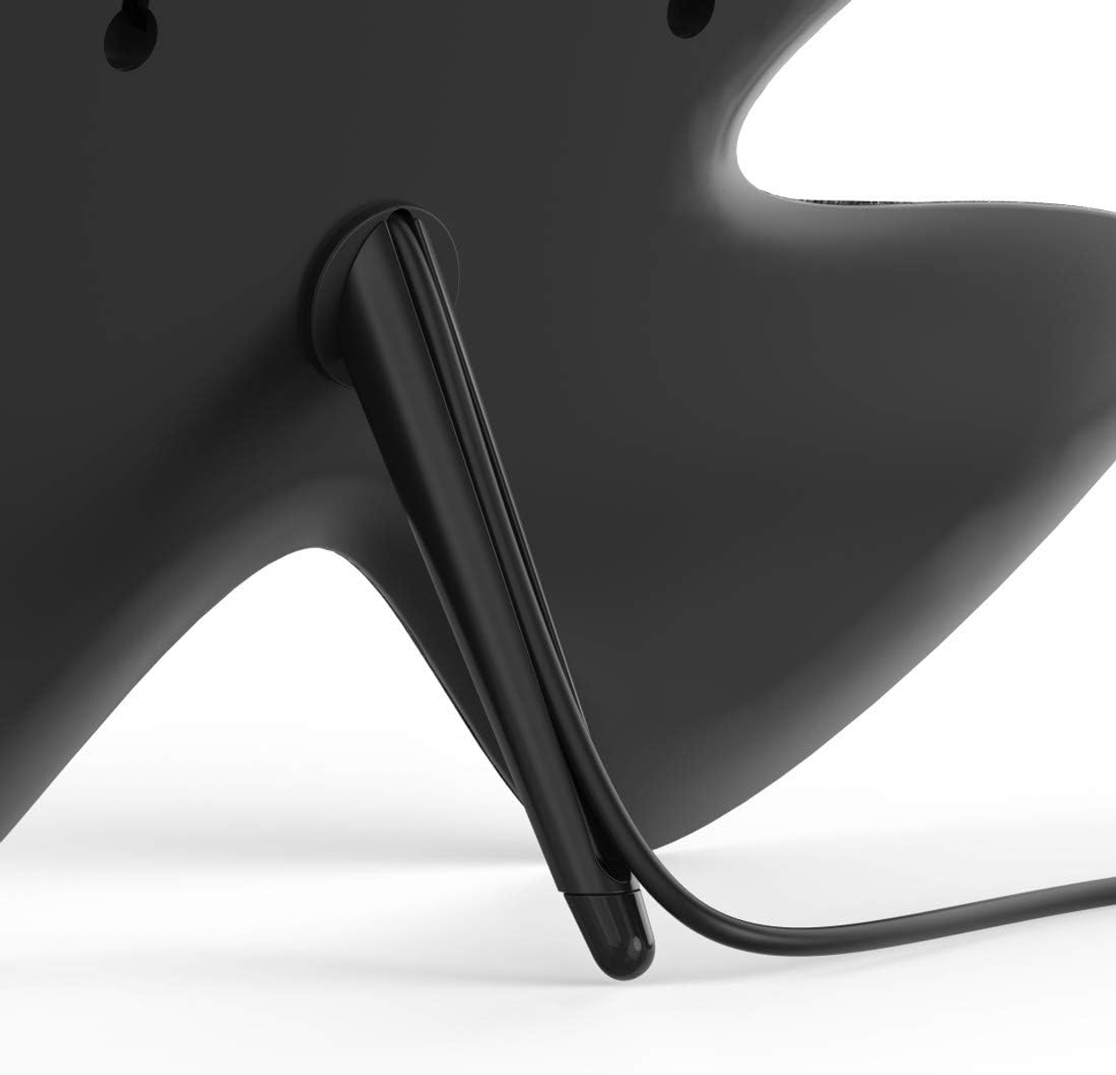 Czarne urządzenie z dołączoną nogą stojaka, zbliżenie na krzywiznę nogi.