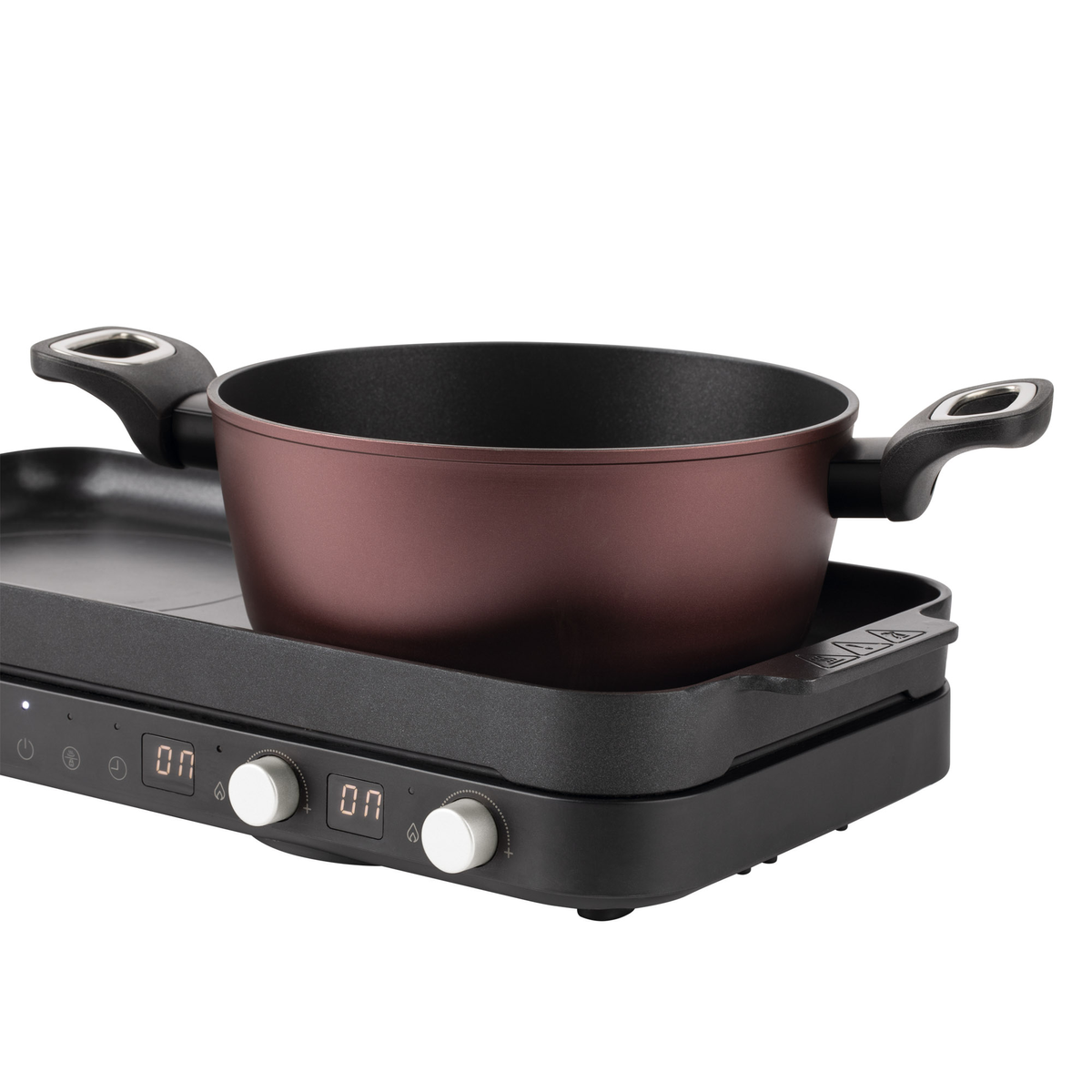 Dispositivo de cocina negro y marrón con una olla encima. Tiene diales y pantallas digitales.