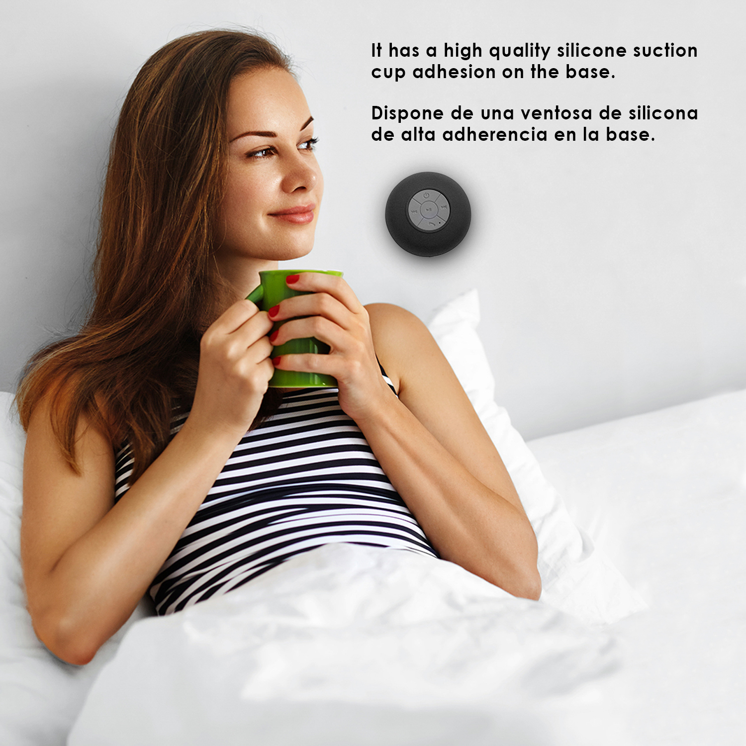 Donna a letto tiene tazza verde, vicino altoparlante nero con ventosa.