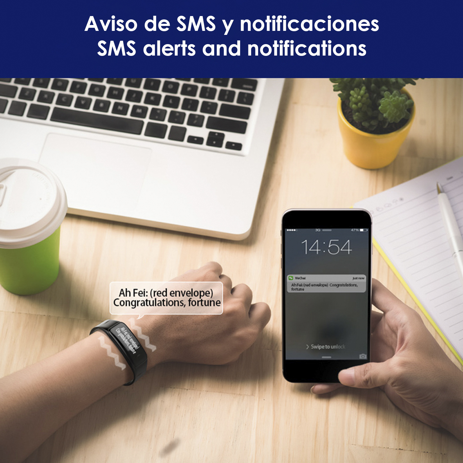 Polso con smartwatch, telefono mostra avviso SMS su scrivania con laptop e pianta.
