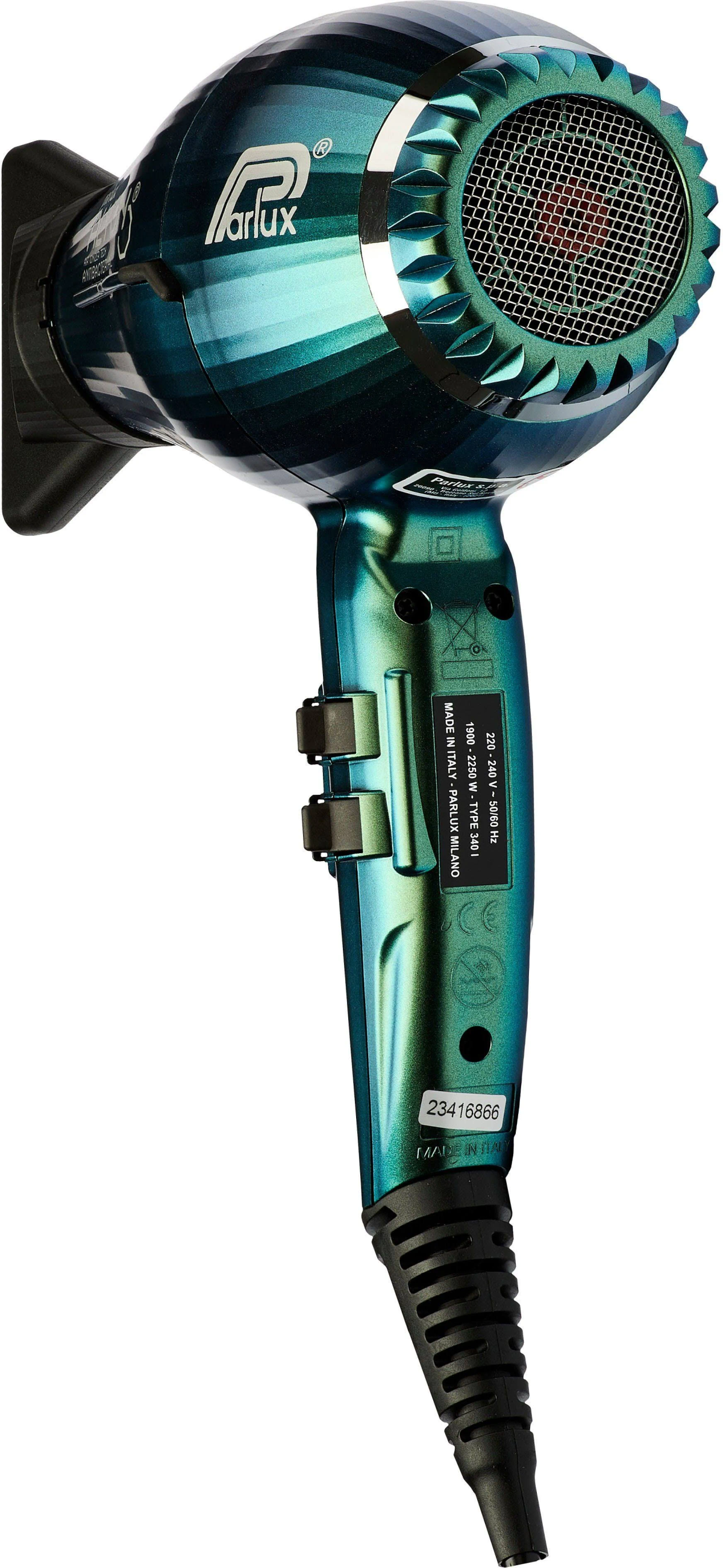 Niebiesko-zielona suszarka do włosów. Jest przechylona w lewo i na białym tle.