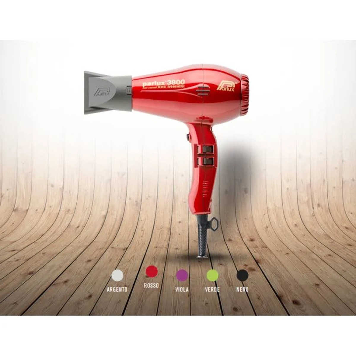 Un asciugacapelli rosso su una superficie di legno, con campioni di colore sotto. L'asciugacapelli ha un ugello grigio.