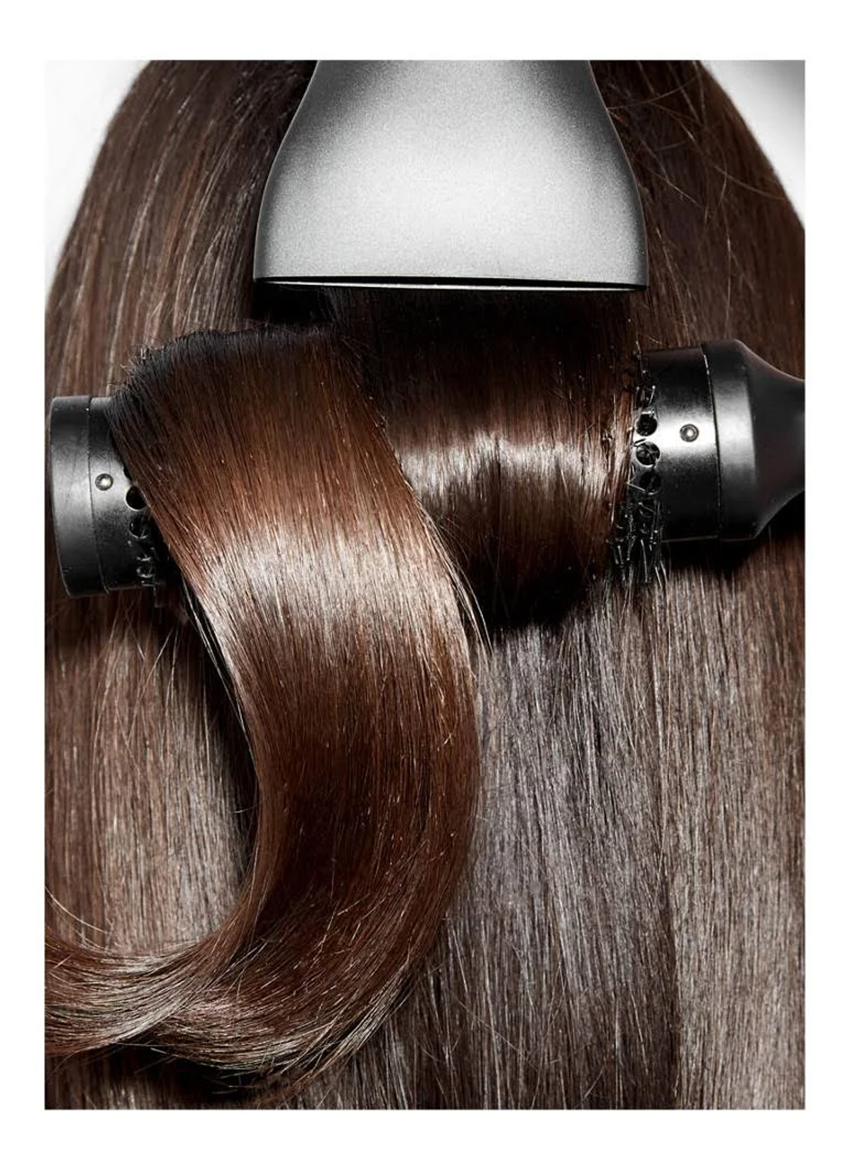 Cheveux coiffés avec un accessoire de sèche-cheveux. Les cheveux bruns sont mis en avant.