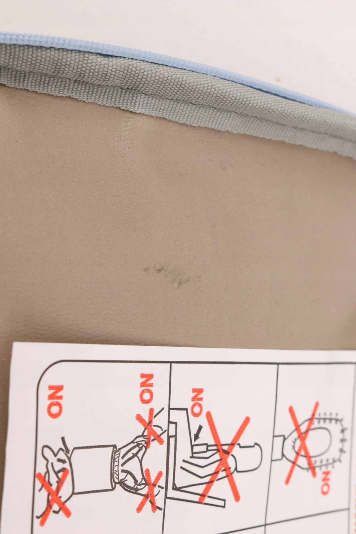 Obraz przedstawia kartkę z przekreślonymi ilustracjami i beżową powierzchnią z małymi śladami.