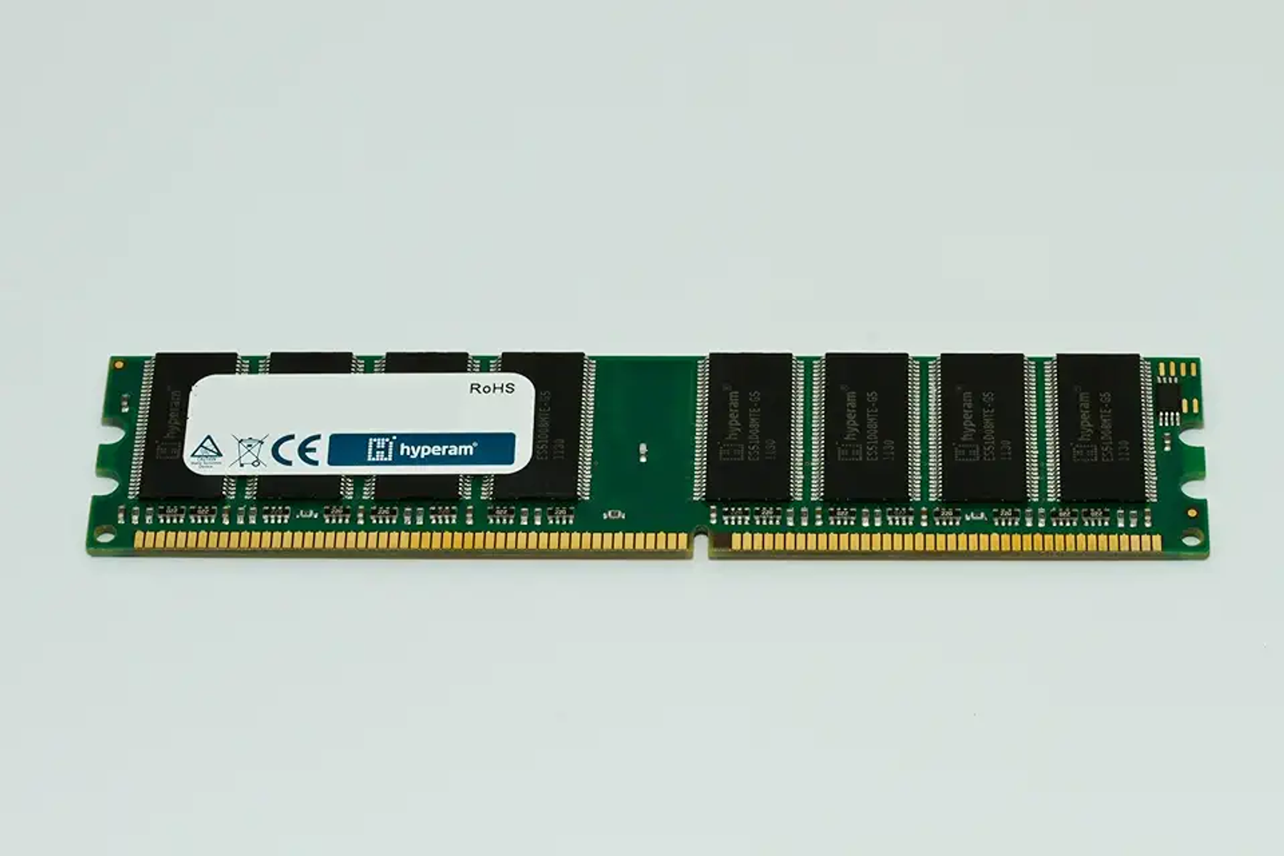 Modulo RAM su sfondo bianco. Ha un'etichetta e più chip neri allineati.