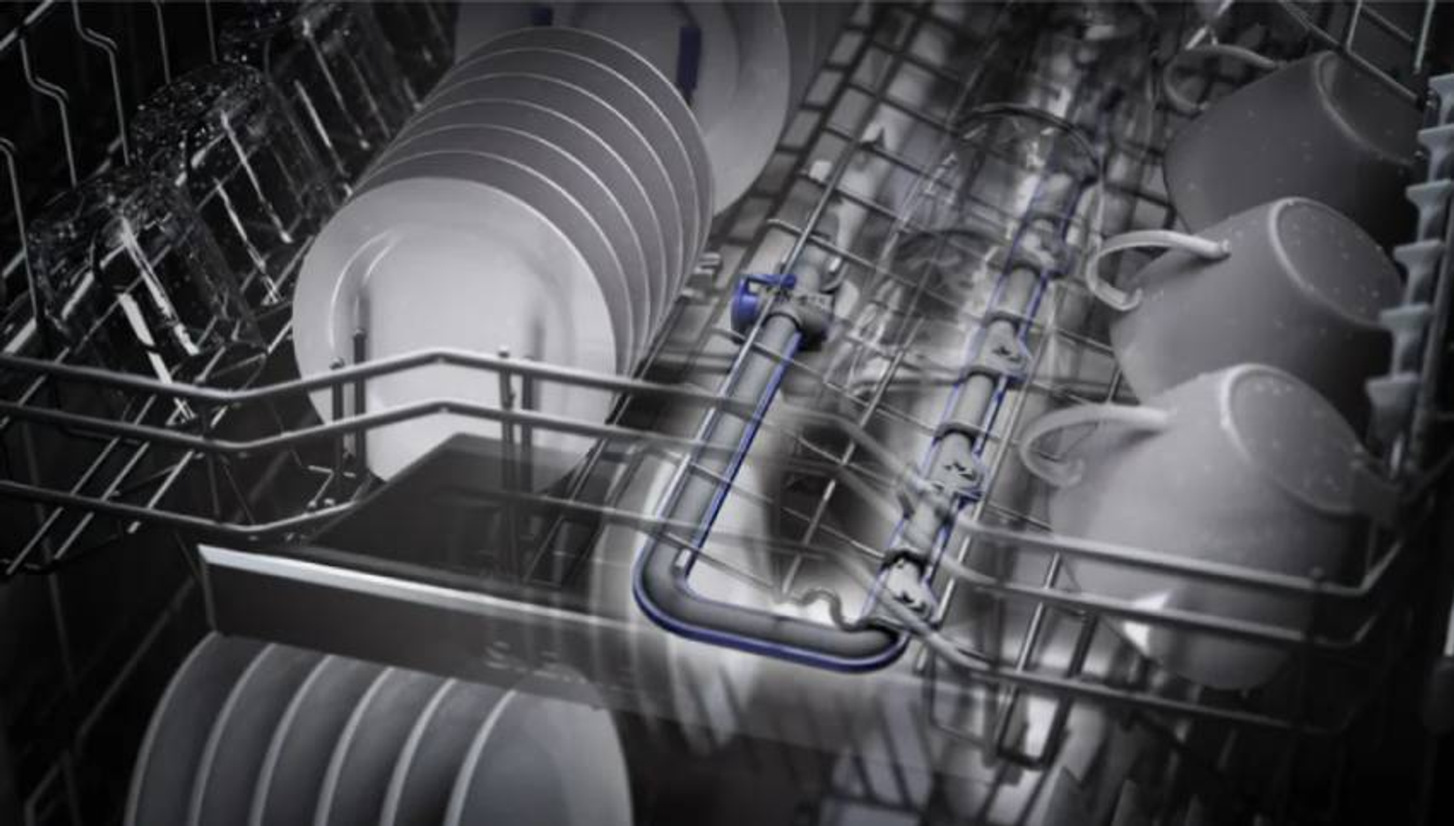 Wnętrze zmywarki z talerzami, szklankami i kubkami ułożonymi na półkach, ujęcie z bliska.