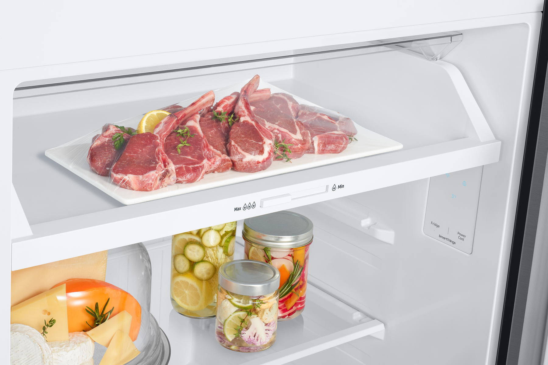 Interior de refrigerador: Carne cruda en plato, frascos de encurtidos y queso. Estantes transparentes.