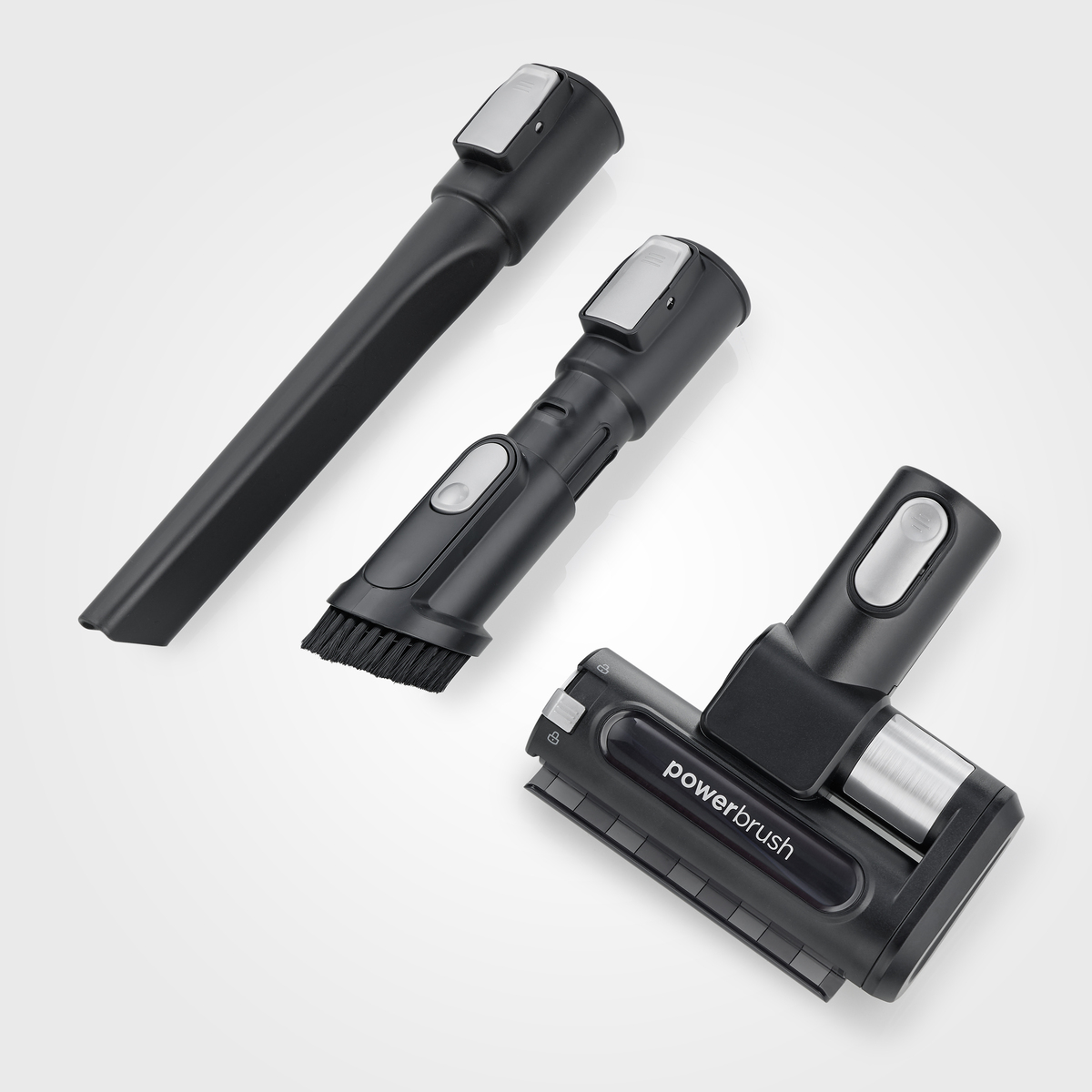 Accesorios de aspiradora: Varilla, cepillo y cepillo eléctrico, todos negros, sobre fondo blanco.