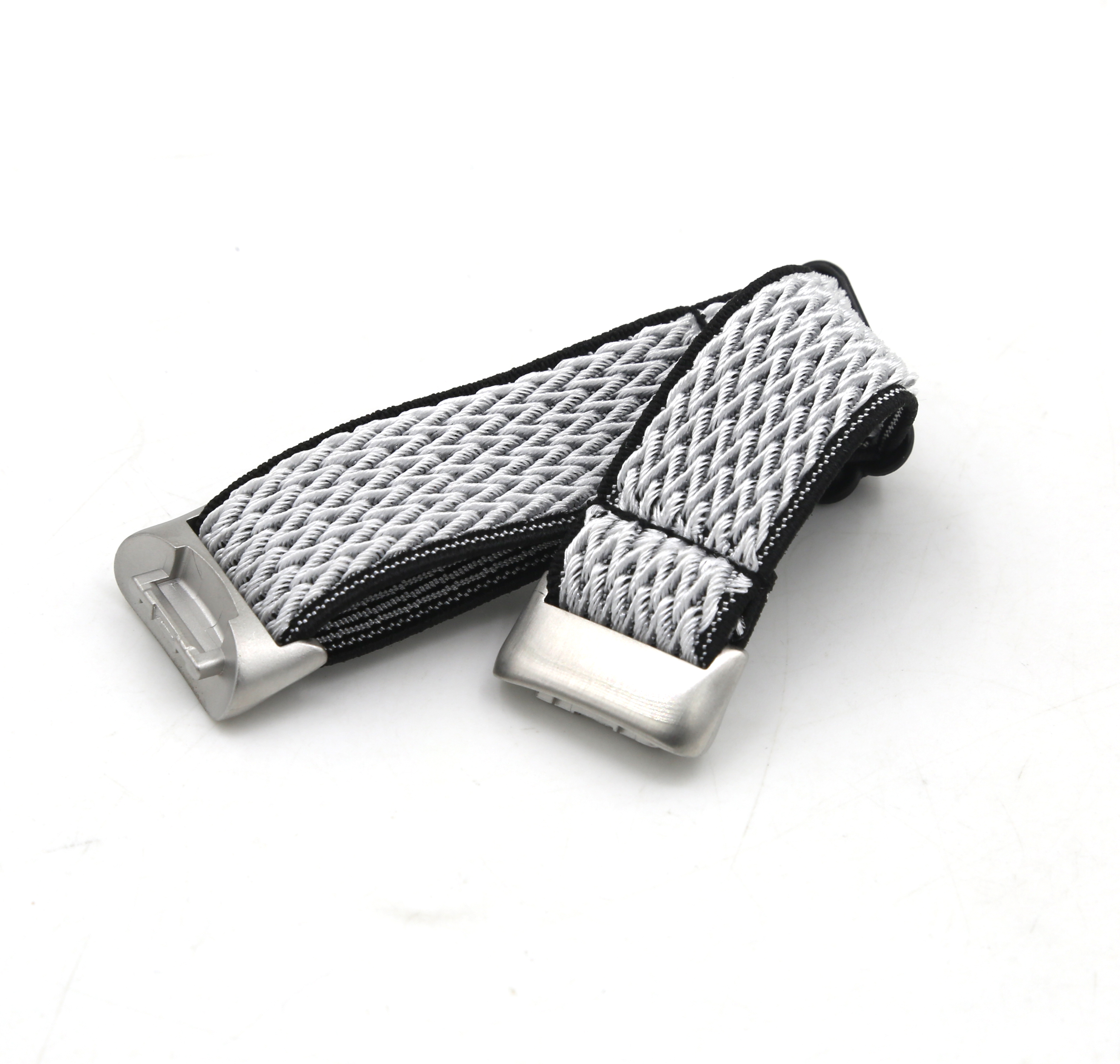 Una correa de reloj con hebilla plateada, de material tejido gris y negro, sobre una superficie blanca.