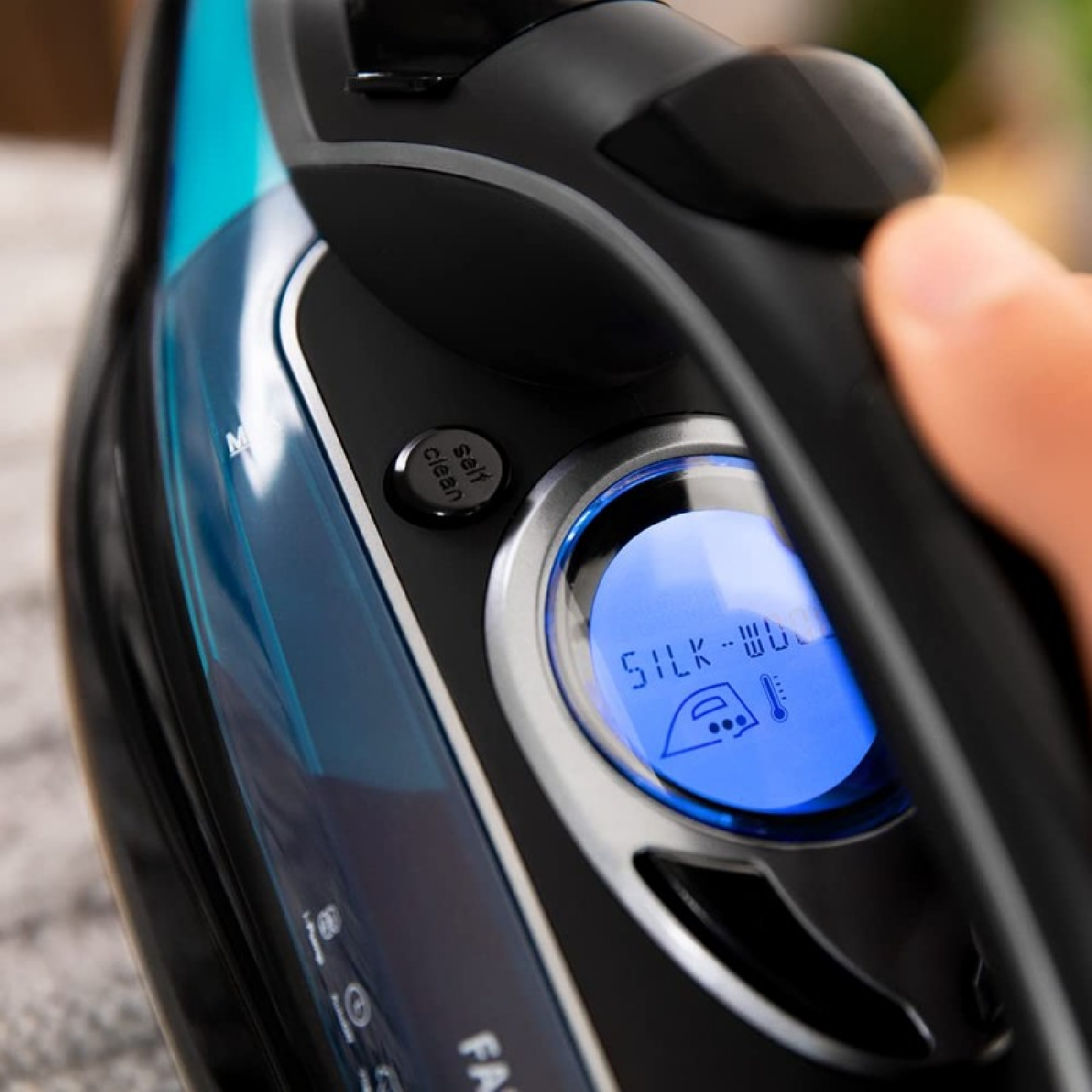 Żelazko z niebieskim podświetlanym wyświetlaczem, pokazującym ustawienia jedwab-wełna.