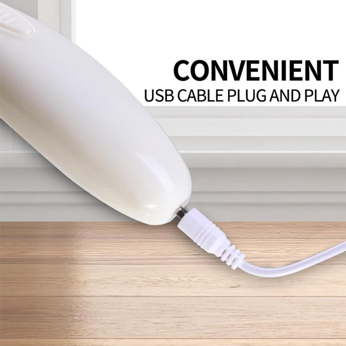 Ein weißes Gerät ist an ein weißes USB-Kabel angeschlossen. Der Hintergrund ist ein Fenster und ein Holzboden.