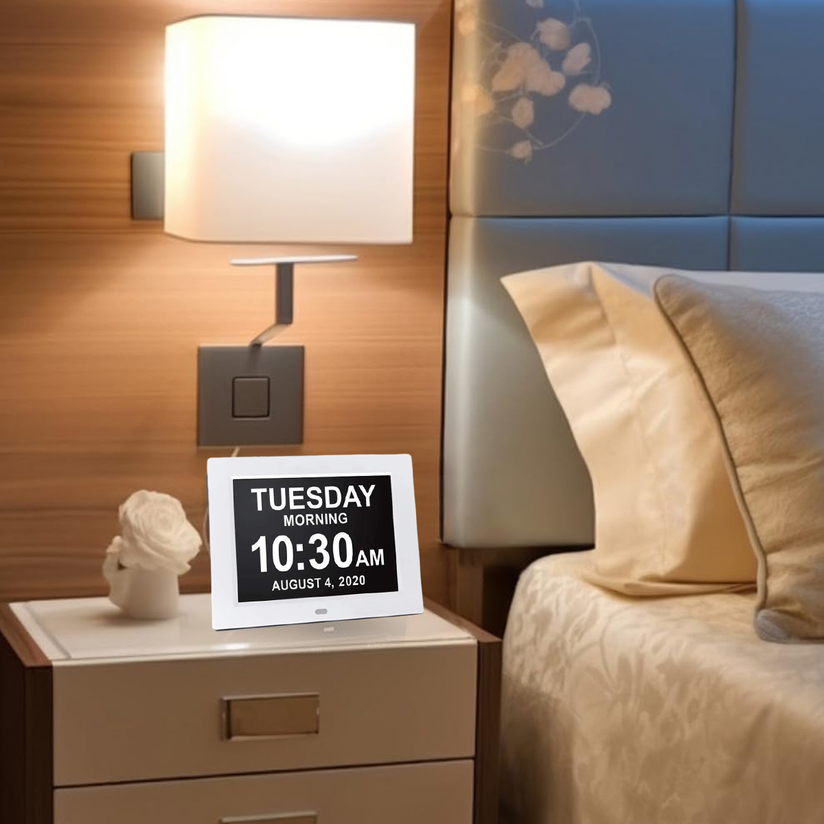 Eine Digitaluhr auf einem Nachttisch, die Datum und Uhrzeit anzeigt.