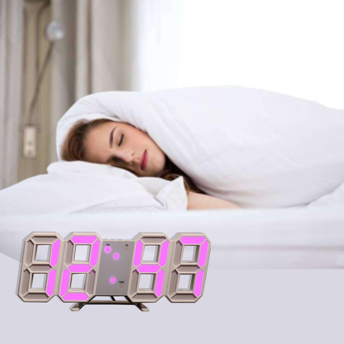 Eine Frau schläft unter einer weißen Decke. Eine Digitaluhr mit pinkfarbenen Ziffern befindet sich im Vordergrund.