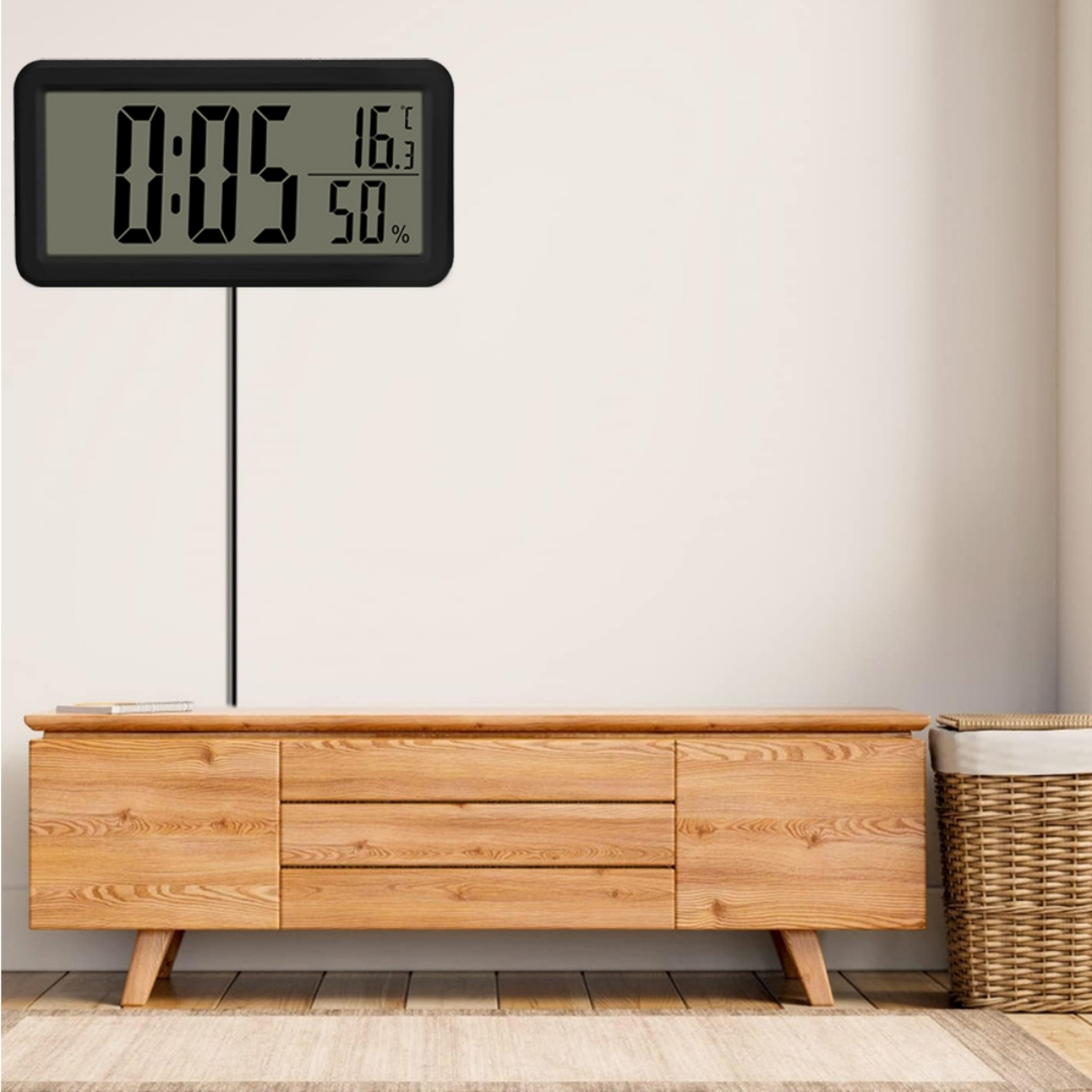 Digitalanzeige, die Zeit, Temperatur und Luftfeuchtigkeit anzeigt. Sie befindet sich auf einem Holzschrank.