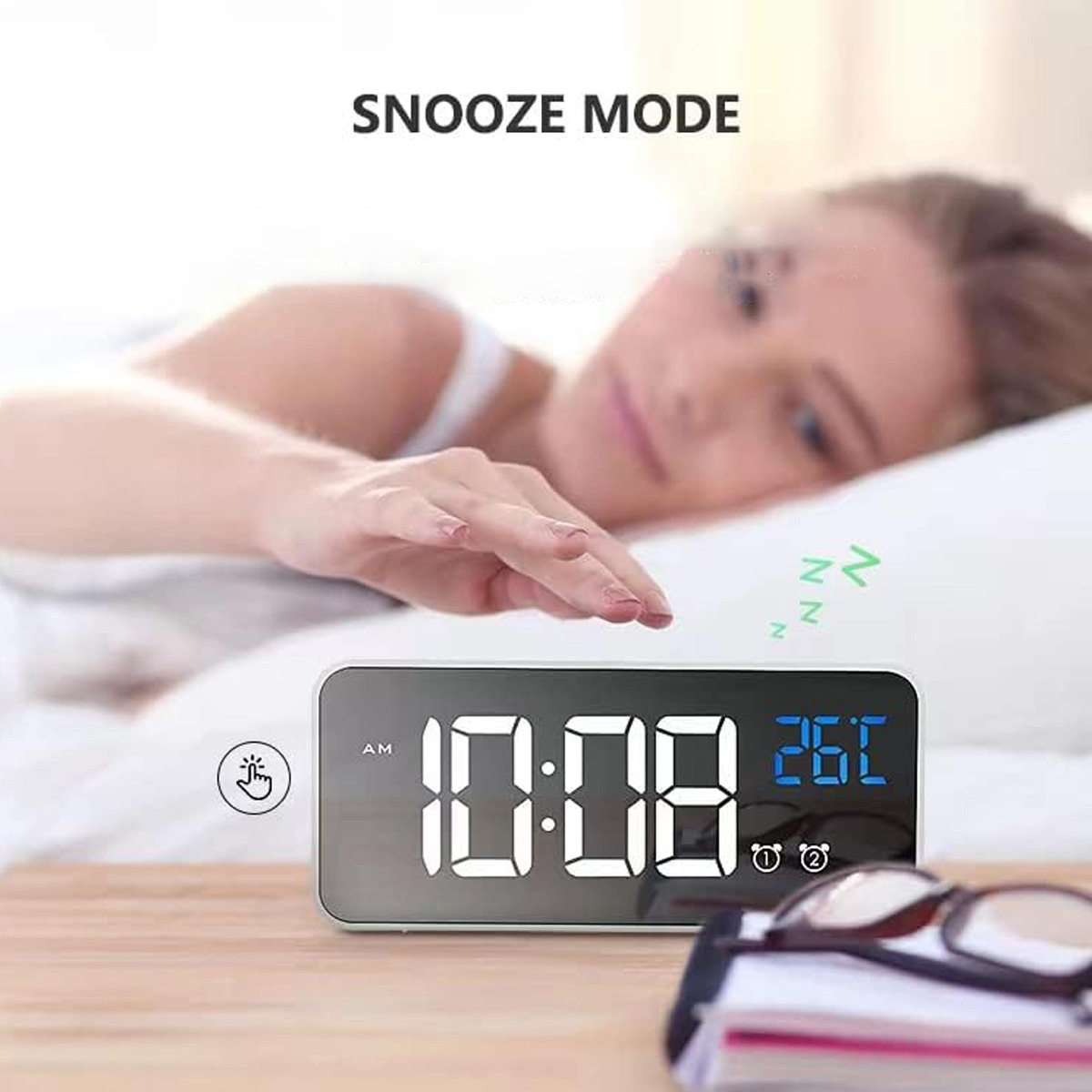 Ein digitaler Wecker, der 10:08 und 26°C anzeigt. Eine Frau ist unscharf im Hintergrund, im Bett.