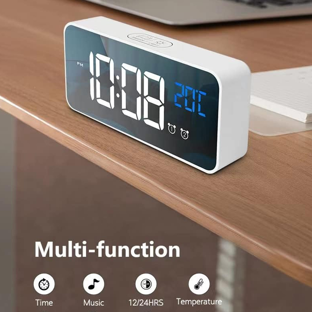 Digitaluhr zeigt 10:08 und 20C. Sie ist weiß, auf Holz. Symbole für Zeit, Musik, Temperatur und 12/24 Std.