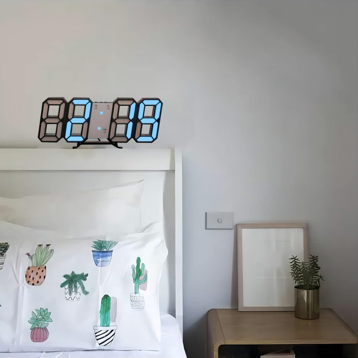 Eine Digitaluhr auf einem Nachttisch, die die Uhrzeit anzeigt. Ein Bett mit Kissen im Vordergrund.