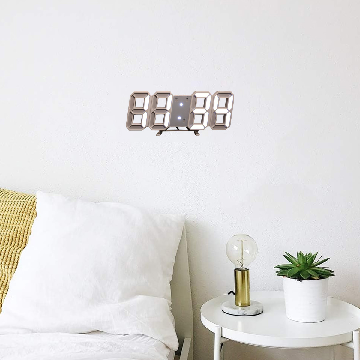 Digitaluhr an einer weißen Wand. Weiße Zahlen, minimalistisches Design, kleiner Tisch, Pflanze und Lampe.
