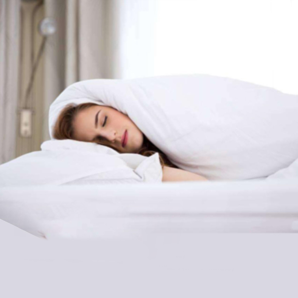 Schlafende Frau im Bett, mit weißer Decke bedeckt. Nur ihr Gesicht sichtbar.