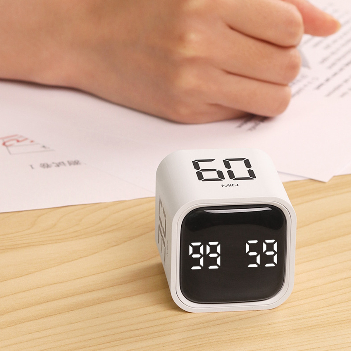 Ein weißer Würfel-Timer mit der Anzeige '60 MIN' und den Zahlen '99 59' auf der Vorderseite.