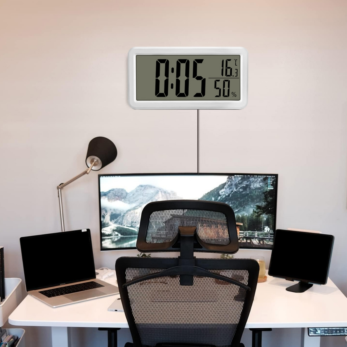 Eine Digitaluhr an der Wand, die Zeit, Temperatur und Luftfeuchtigkeit anzeigt.