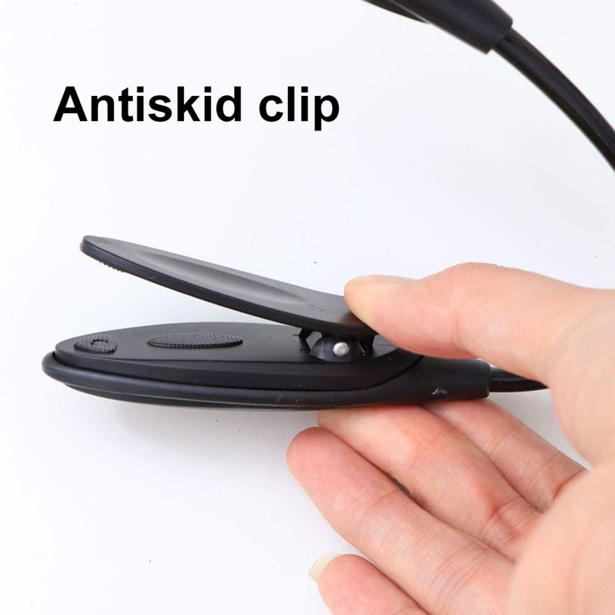 Eine Hand, die einen schwarzen Clip hält, der Teil einer flexiblen Schreibtischlampe ist.