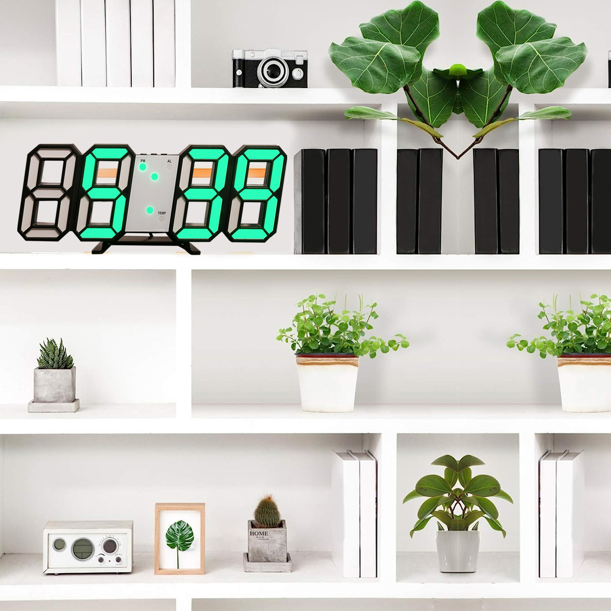 Weiße Regale mit Digitaluhr, Pflanzen, Büchern und einer Kamera. Modernes Innendesign.