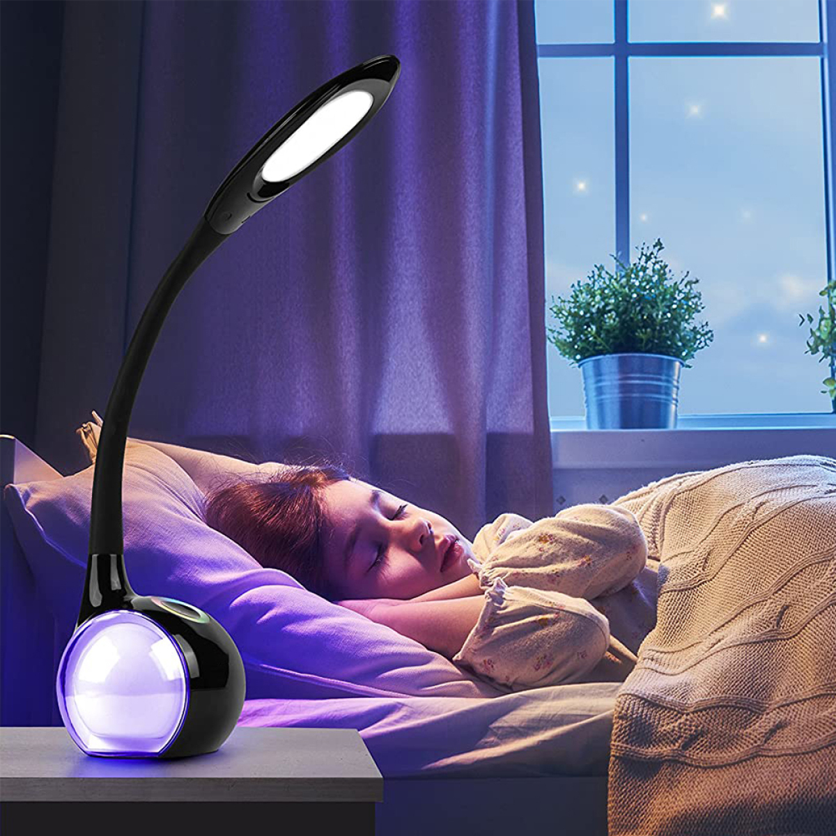 Ein Kind schläft im Bett. Eine schwarz-weiße Lampe steht auf dem Nachttisch und strahlt lila Licht aus.