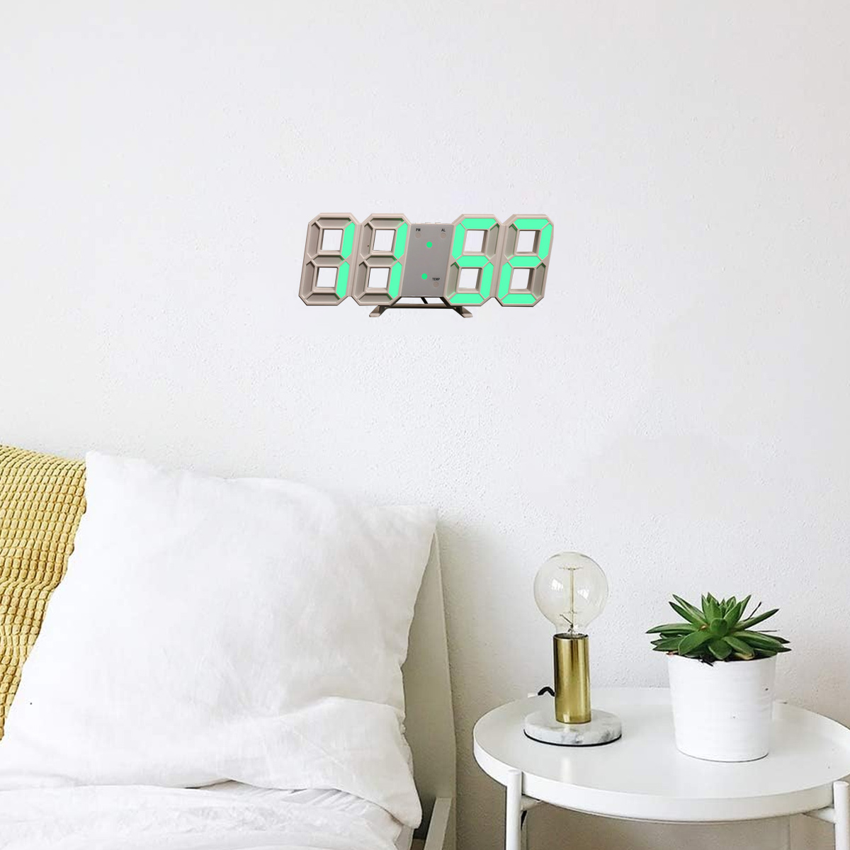 Digitaluhr mit grünen Zahlen an einer weißen Wand, mit Beistelltisch und kleiner Pflanze.
