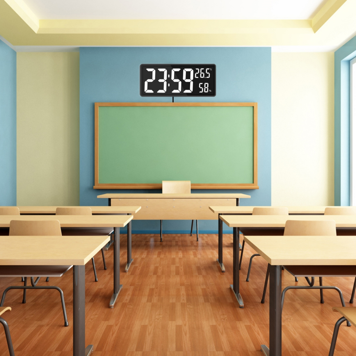 Ein Klassenzimmer mit Tischen, einer grünen Tafel, einer Digitaluhr mit Zeit und Temperatur.