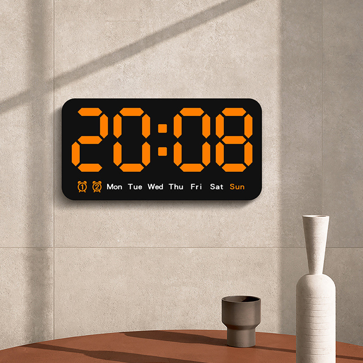 Digitaluhr mit 20:08, mit Wochentagen. An einer Wand, mit dekorativen Vasen.