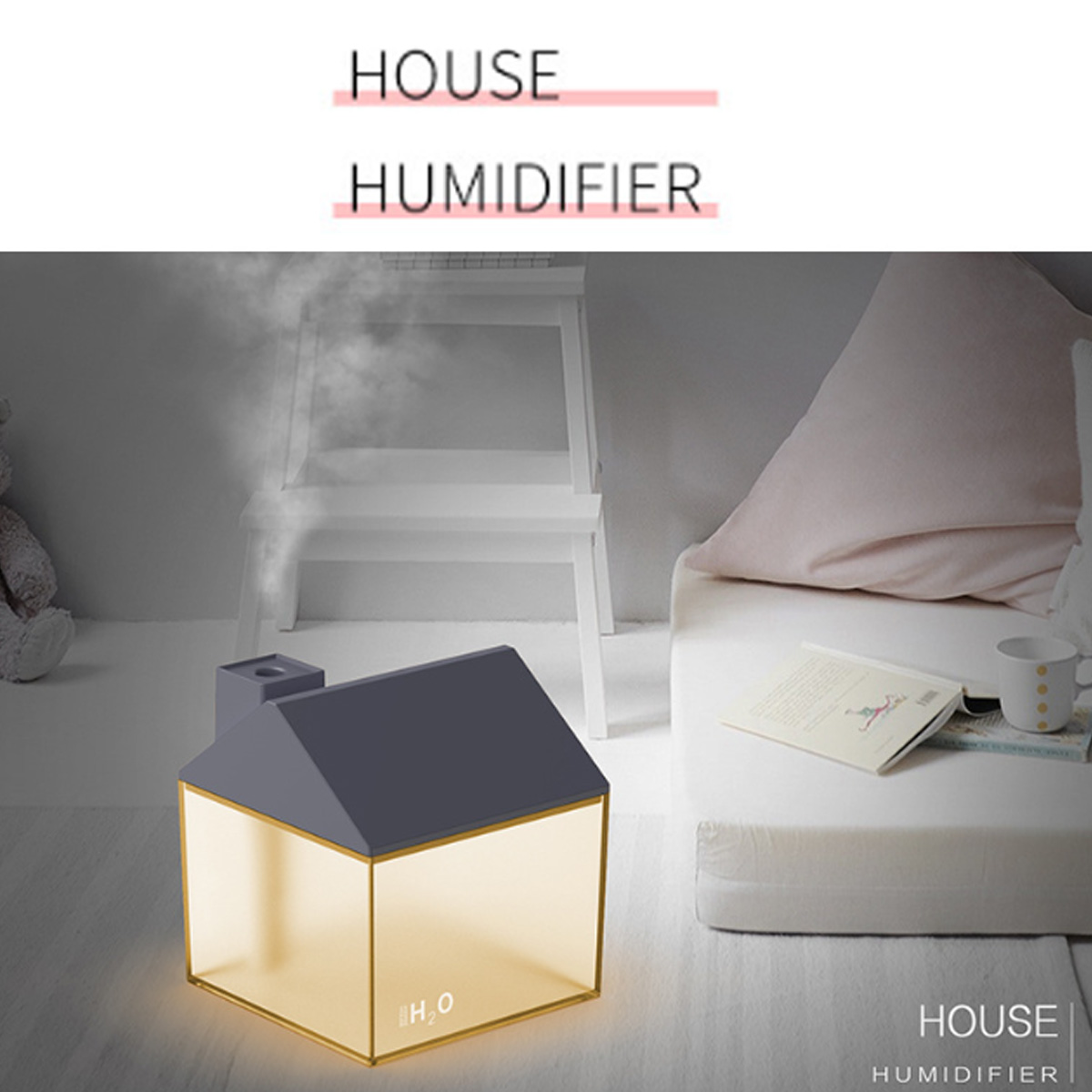 Ein hausförmiger Luftbefeuchter mit aufsteigendem Dampf steht auf einem Tisch mit Buch und Lampe.