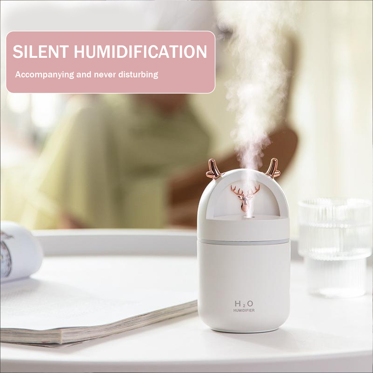 Weißer Luftbefeuchter mit Hirschkopf-Design, emittiert Nebel. Text-Overlay: Stille Befeuchtung.